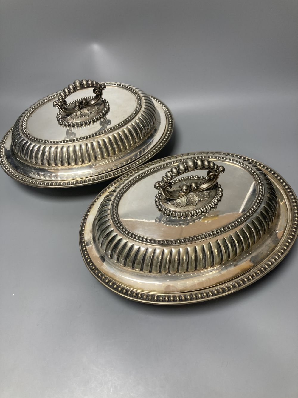 A pair of silver plated oval entree dishes, with covers and detachable handles, 29cm
